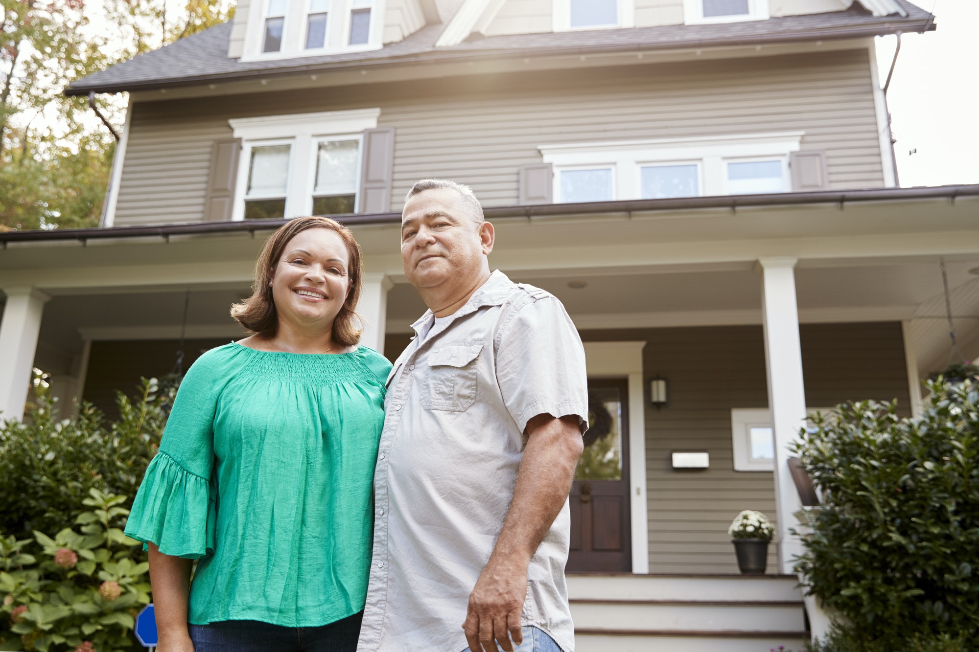 Portrait Of Smiling Senior Couple In Front Of Their Home