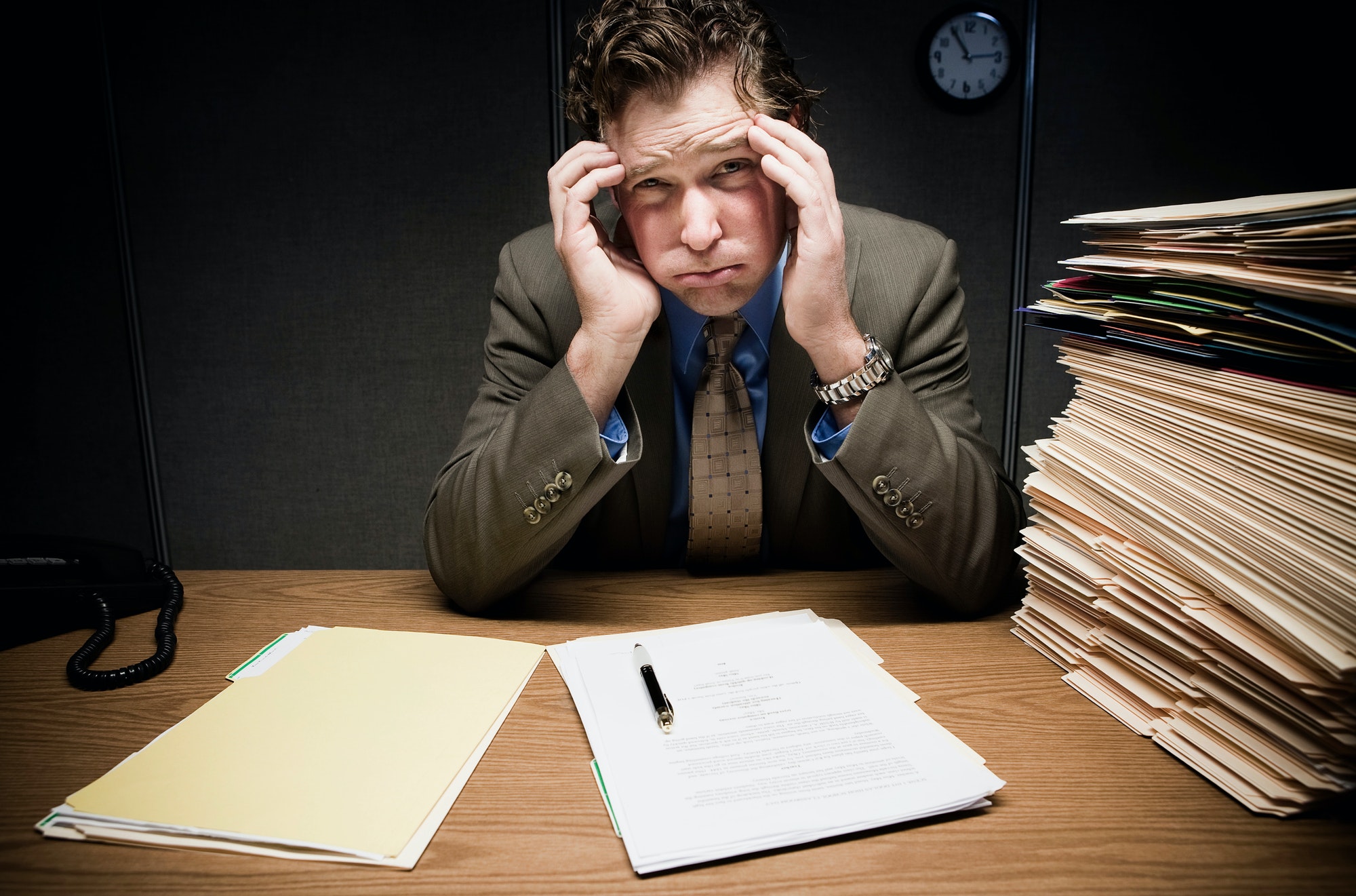 Stressed man at desk with paperwork